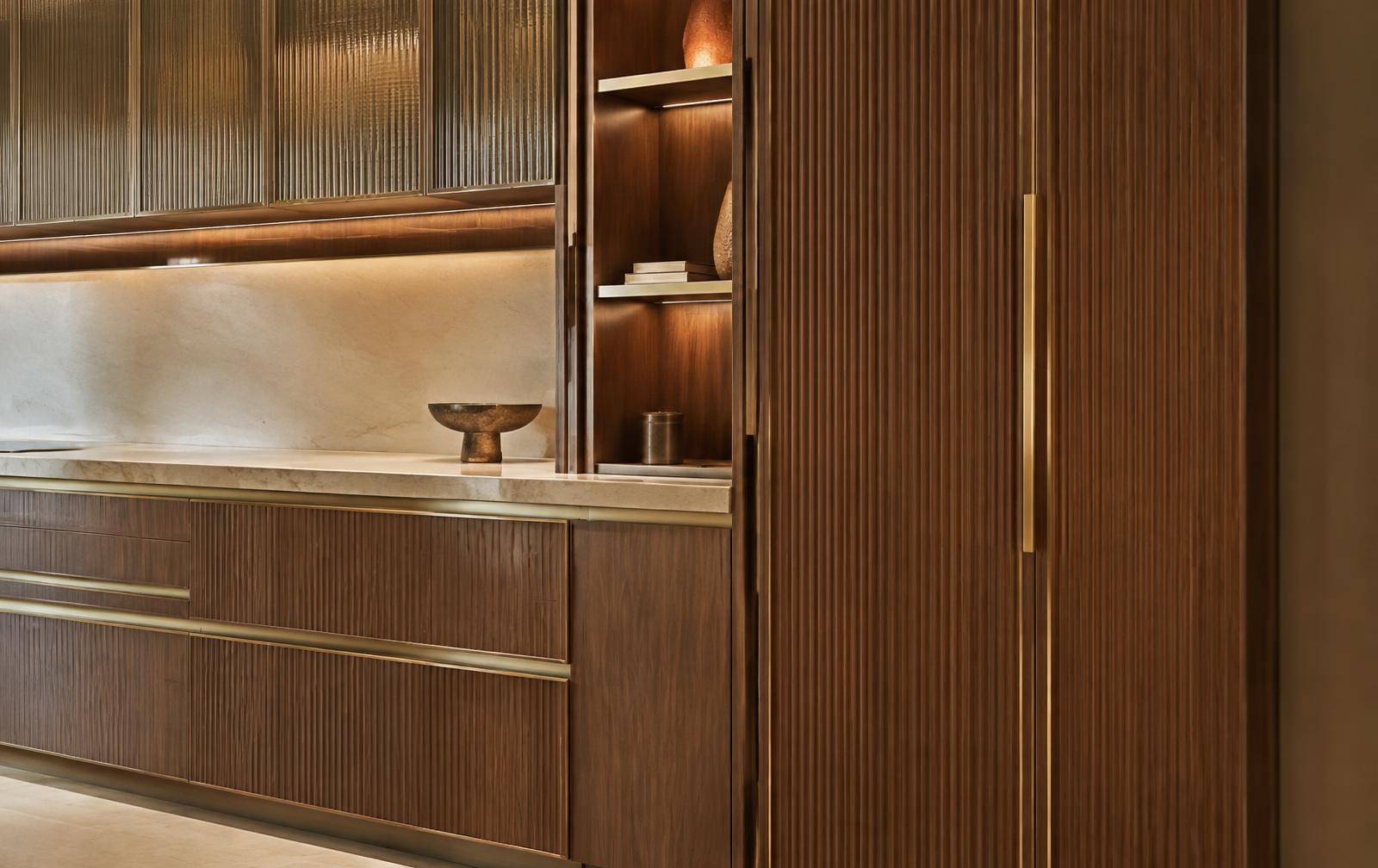 Bespoke walnut joinery with muted gold details and warm integrated lighting